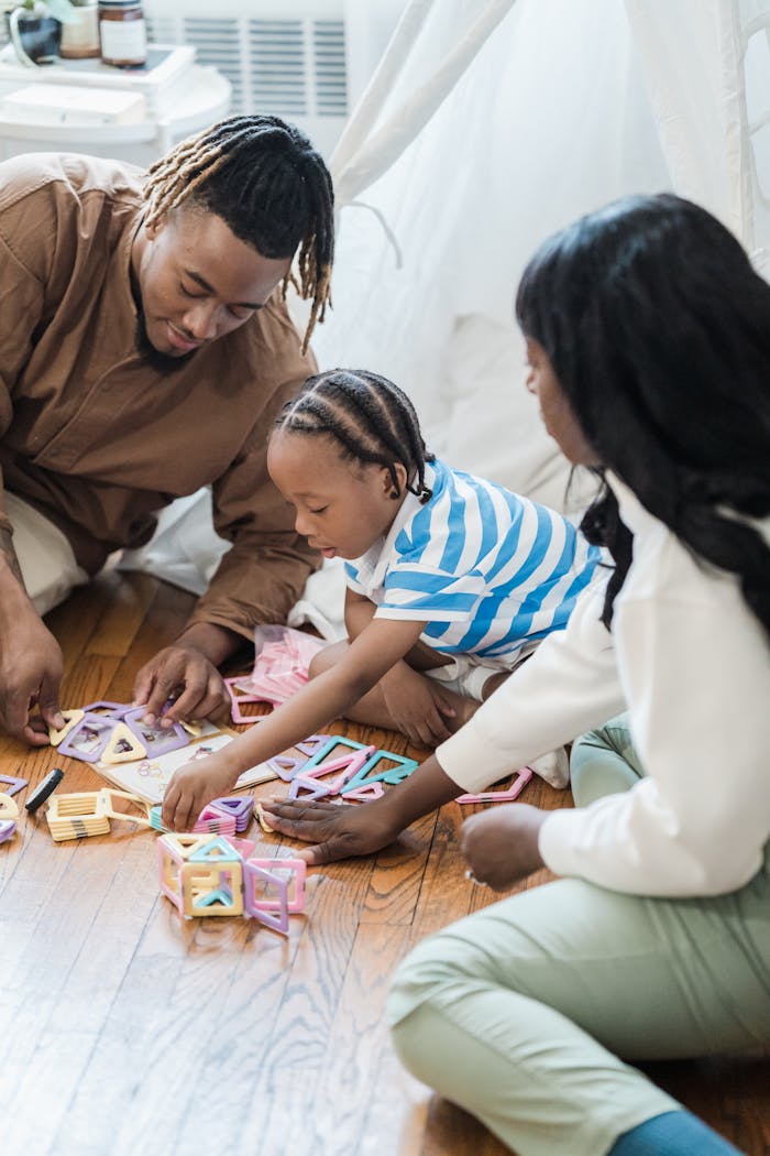 A joyful family spending quality time playing with colorful blocks on a wooden floor indoors.